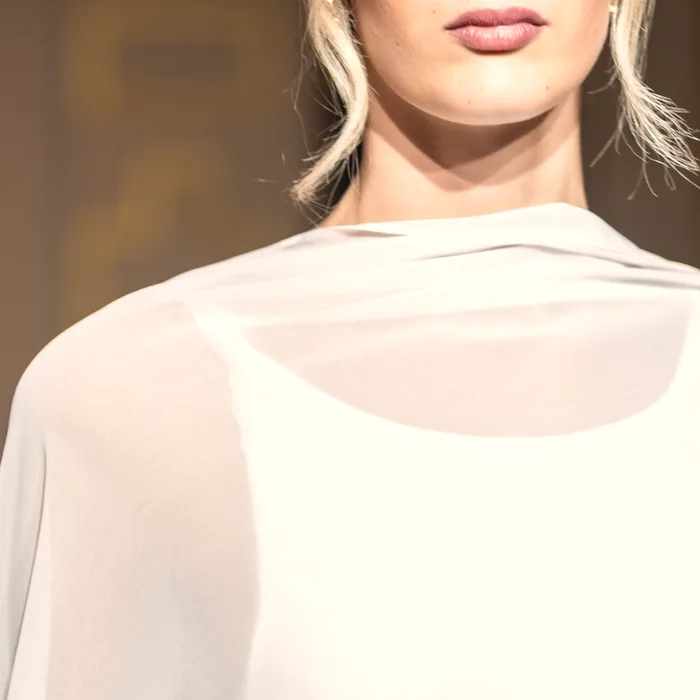 Drappeggio in chiffon sul décolleté di un abito da sposa, dettaglio ravvicinato